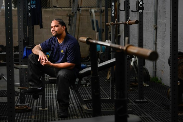 At the group home in Hillcrest, United Levao sits in the weightlifting area, where, when he was living here, he spent a lot of his free time when he wasn't working or attending class. United was 15 when he killed a rival gang member. He was sentenced as an adult and ultimately sent to state prison. (Nelvin C. Cepeda / The San Diego Union-Tribune)