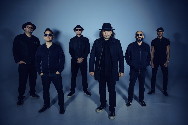 Six bank members dressed in black pose against a blue background