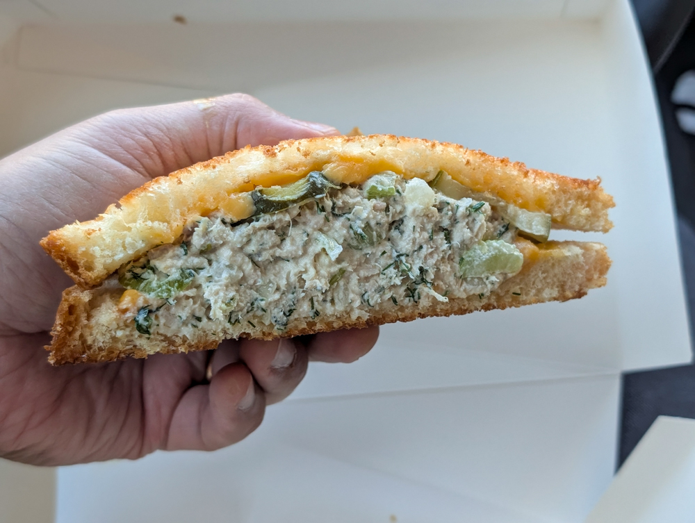 Hand holdes a tuna sandwich.