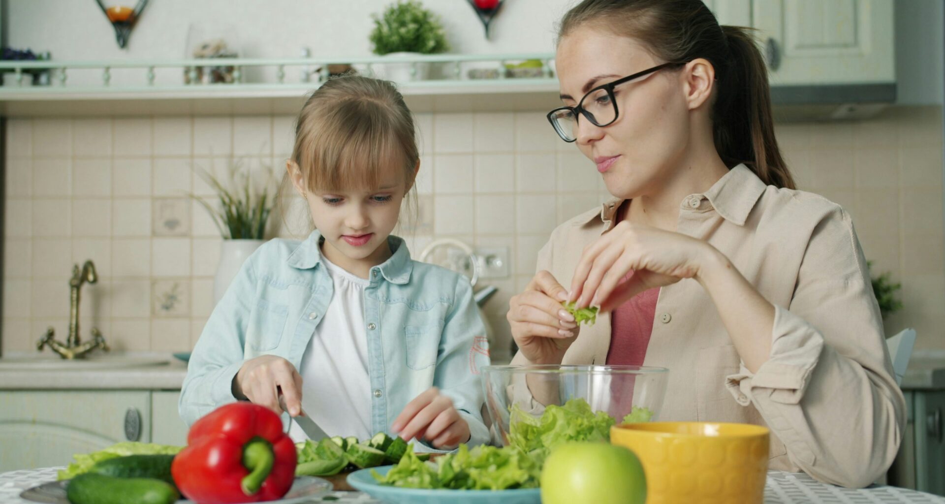 A woman and young girl prepare lunch.