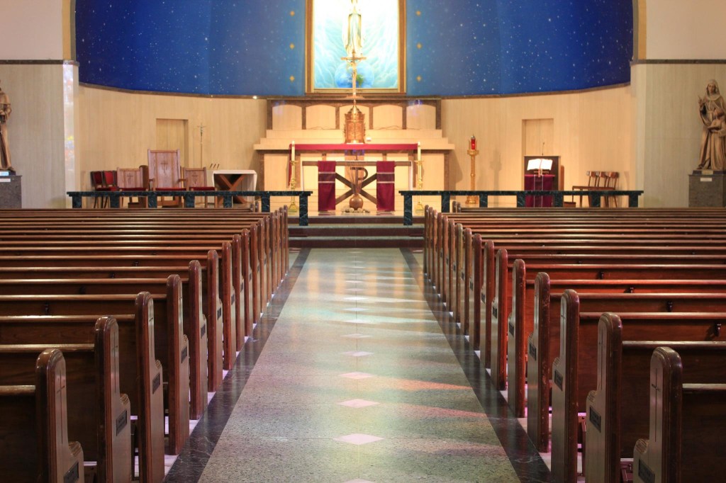 Interior view of St. Mary Parish in Sacramento, California, showing rows of wooden pews leading to the altar.
