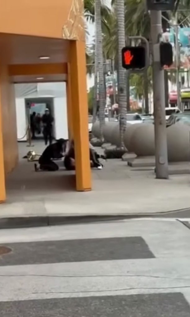 An armed robbery on Rodeo Drive with people kneeling on the sidewalk.