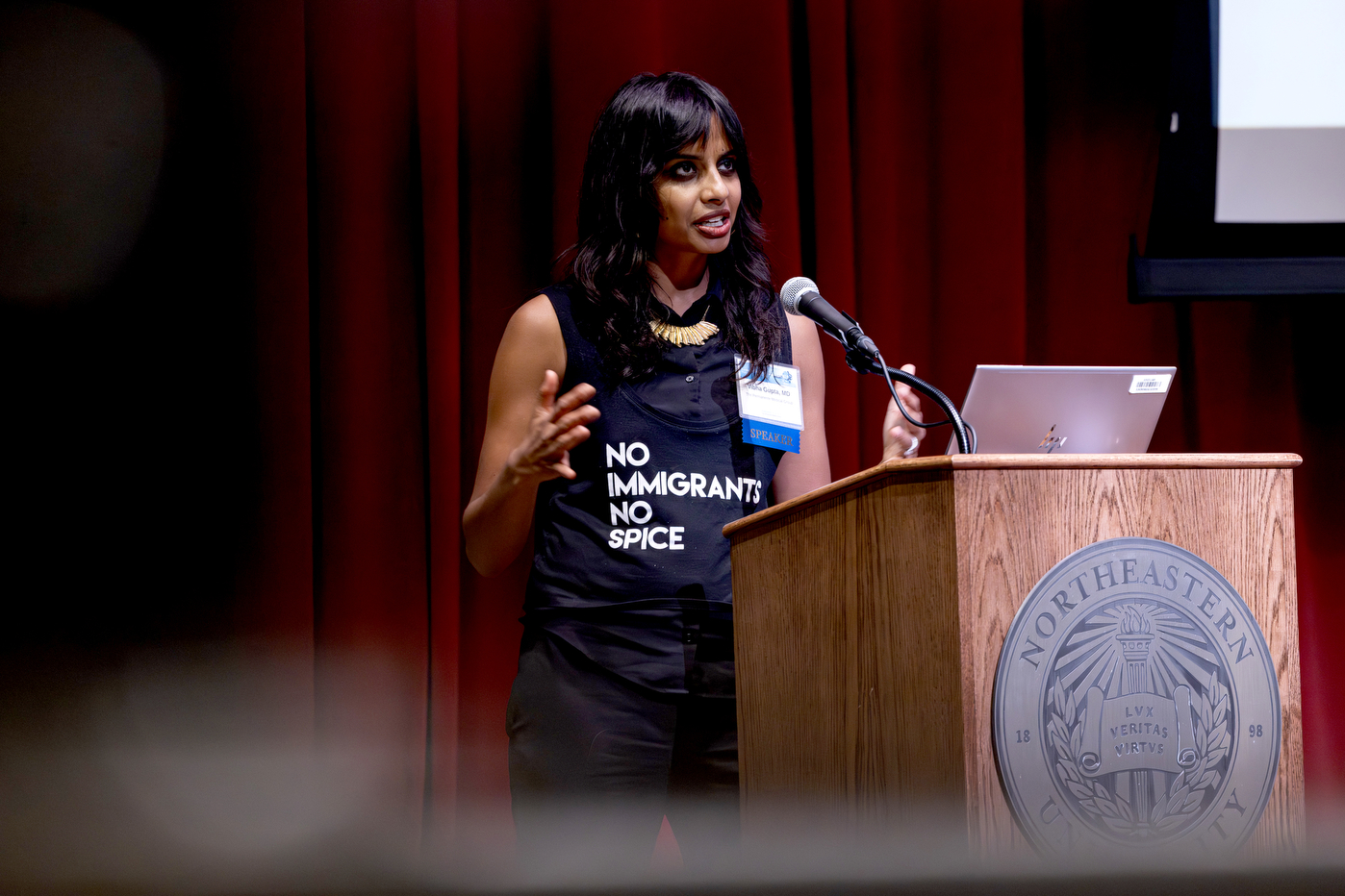 A speaker addresses the audience at a Northeastern University podium during the Global Health Consortium in Oakland.