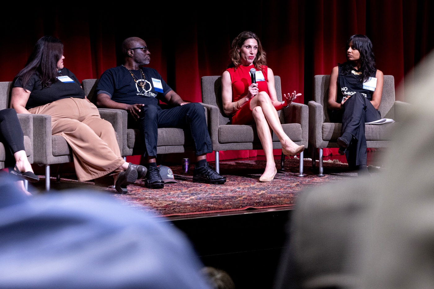 A panel of four speakers discusses global health strategies on stage during the Global Health Consortium at Northeastern's Oakland campus. 