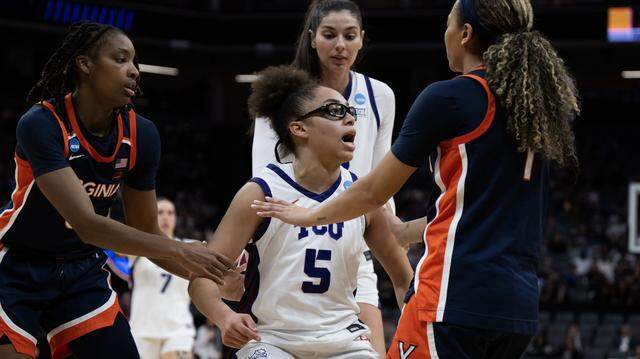 Texas Christian University Horned Frogs guard Olivia Miles (5) is restrained by Virginia Cavaliers guard Paris Clark (1) after a hard foul in the first half of an NCAA Women’s Basketball Tournament Sweet 16 game Saturday at Golden 1 Center in Sacramento.