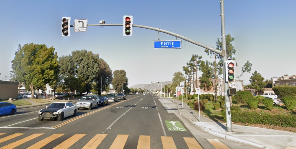 Street view of Perris Boulevard in Moreno Valley, with a sign indicating "Perris 15000+ BI" above the roadway.