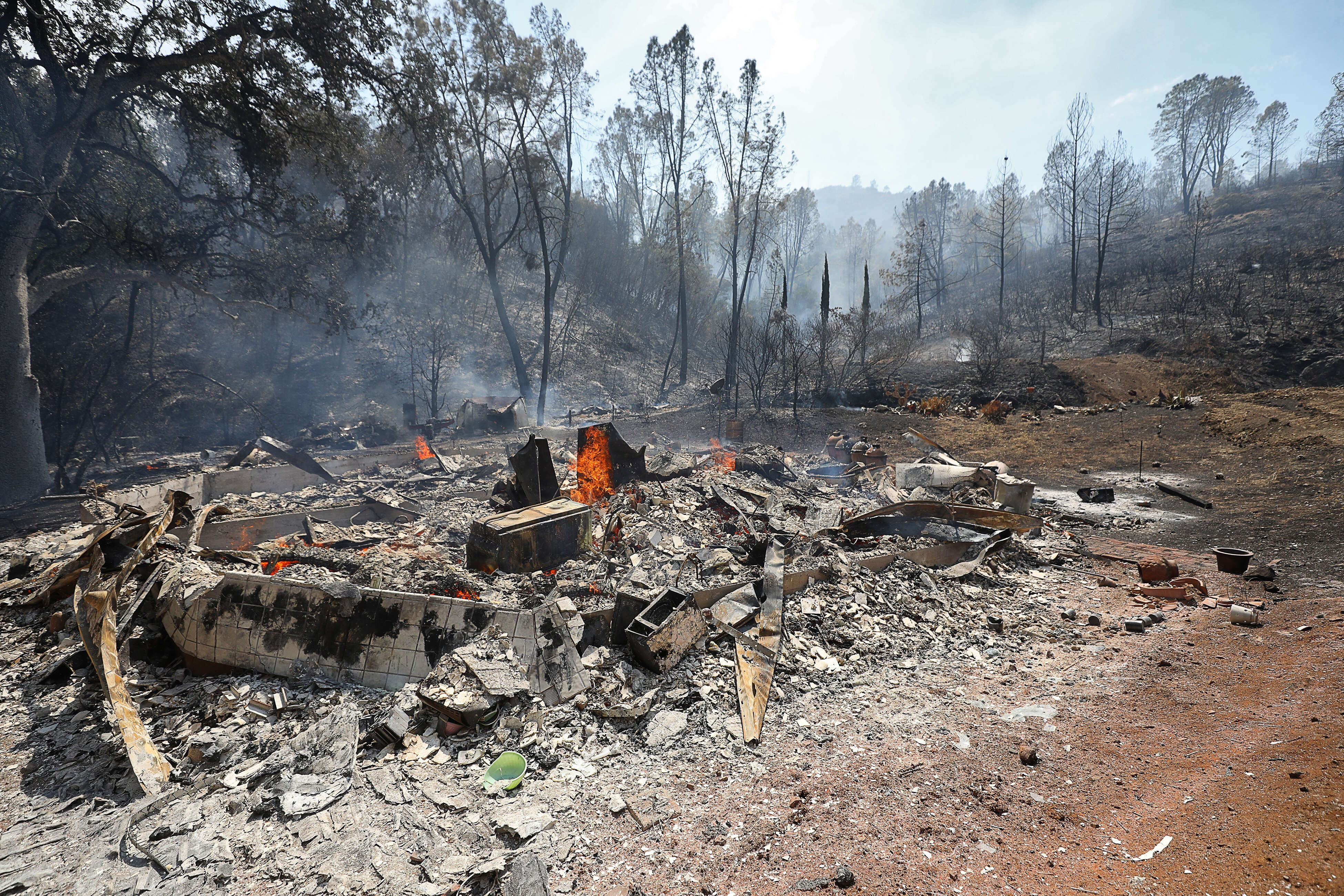 A home along Chiles Pope Valley Road continues to smolder...