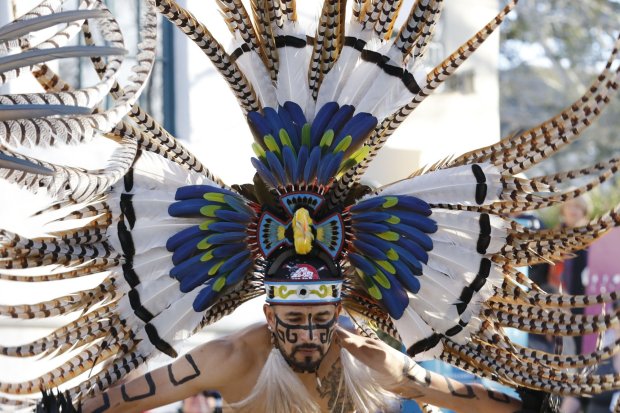 A member of Calpulli Yaocuauhtli performs a traditional Aztec dance on Pacific St. in front of Colton Hall during the opening ceremony of First Night Monterey 2017 on Saturday, December 31, 2016 in Monterey, Calif. (Vernon McKnight/Herald Correspondent)