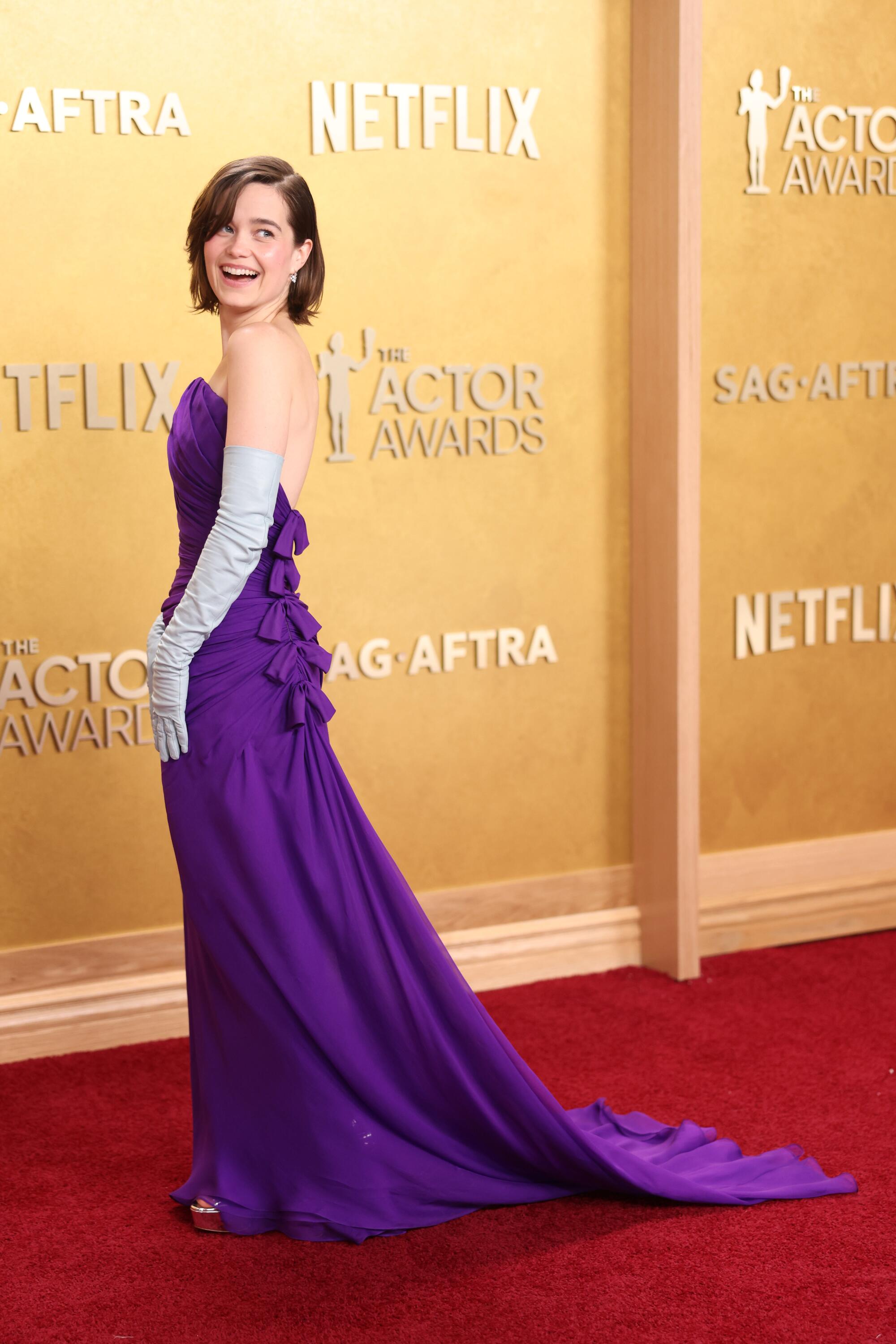 Sarah Catherine Hook, in a purple gown, smiles on the red carpet. 