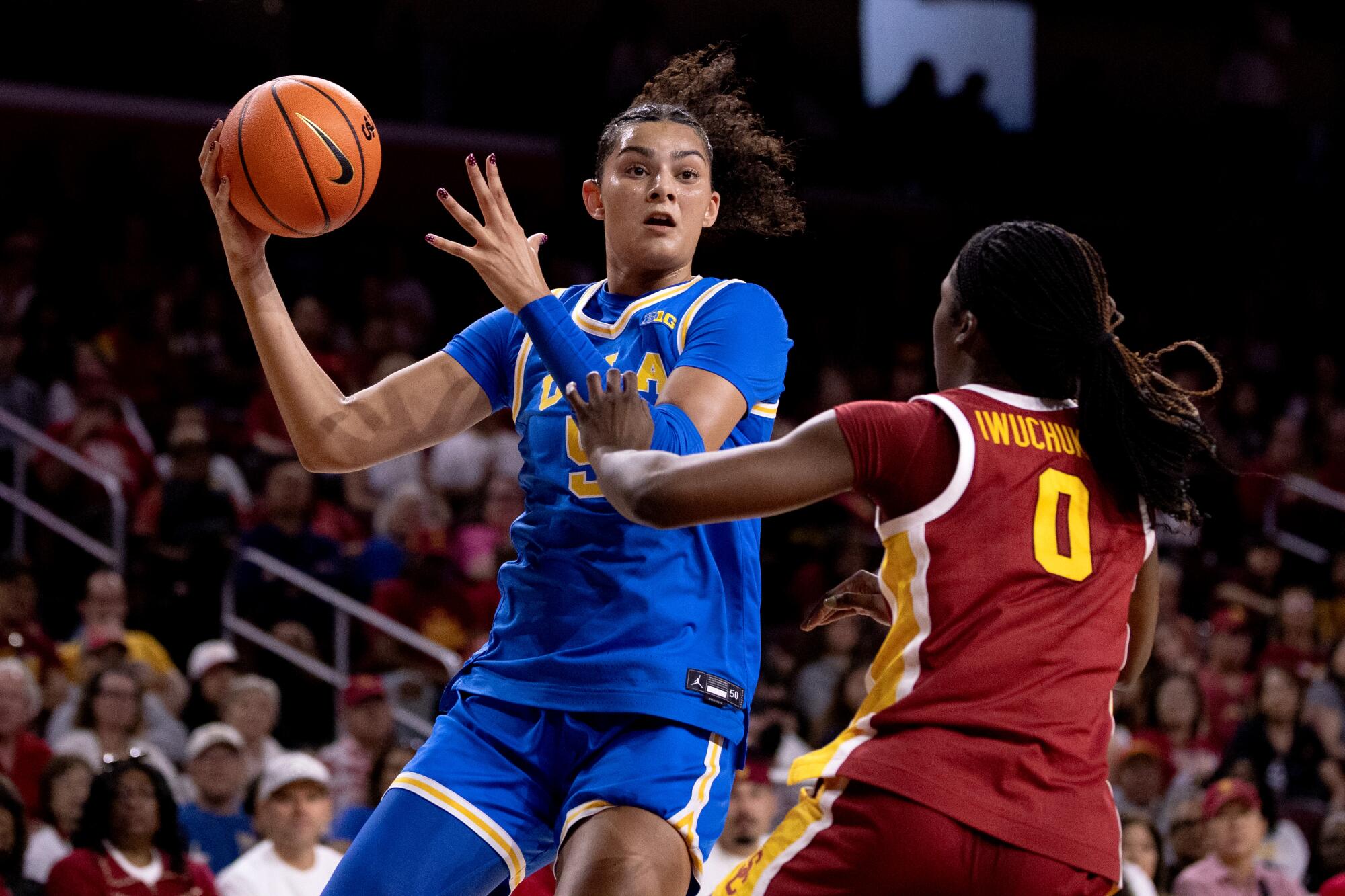 UCLA center Lauren Betts, left, controls the ball in front of USC forward Vivian Iwuchukwu during the first half Sunday.