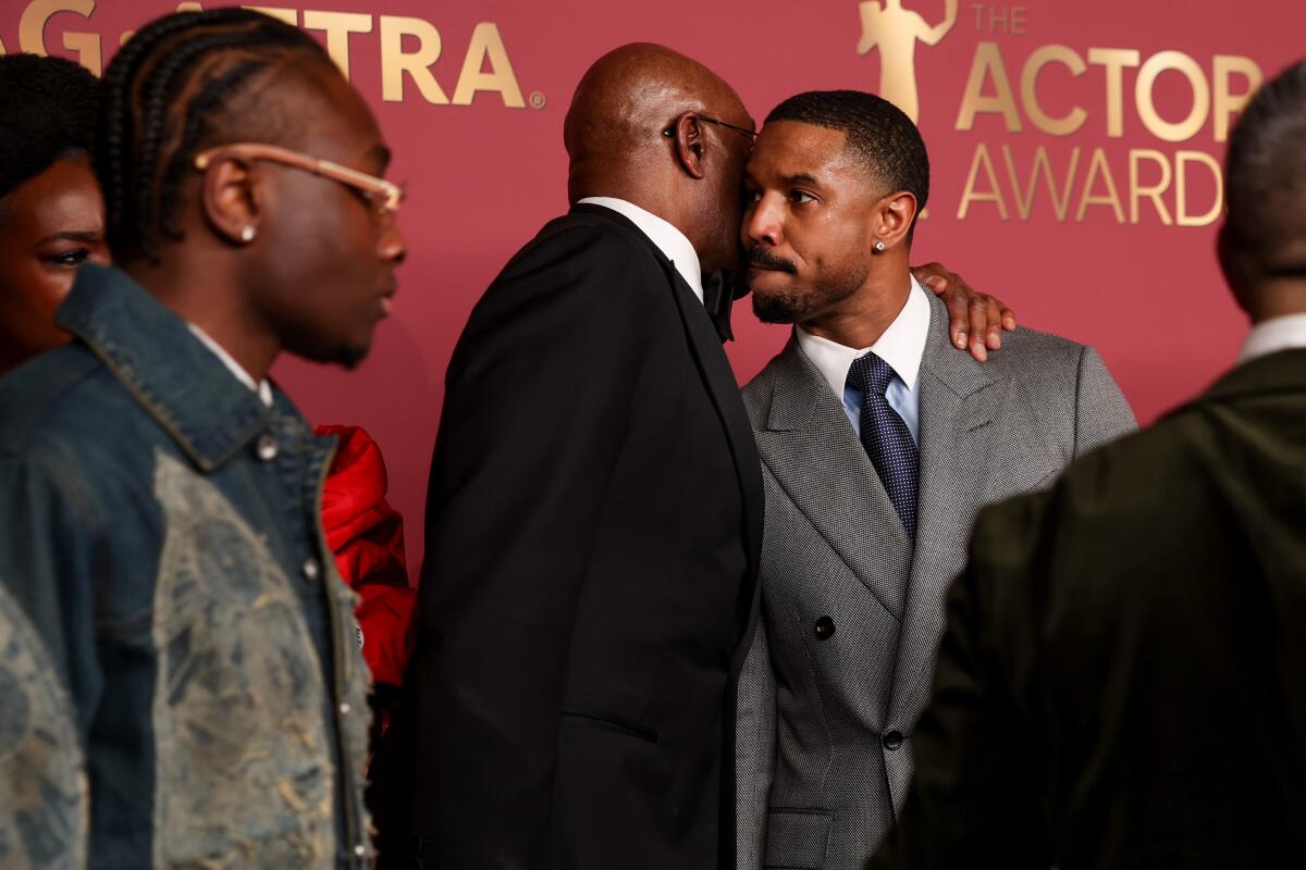 Delroy Lindo whispers in the ear of Michael B. Jordan backstage at the 2026 Actor Awards.