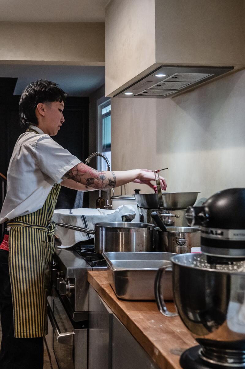 Grain of salt co-founder Kai Nguyen, a private chef checks on the chocolate mousse.