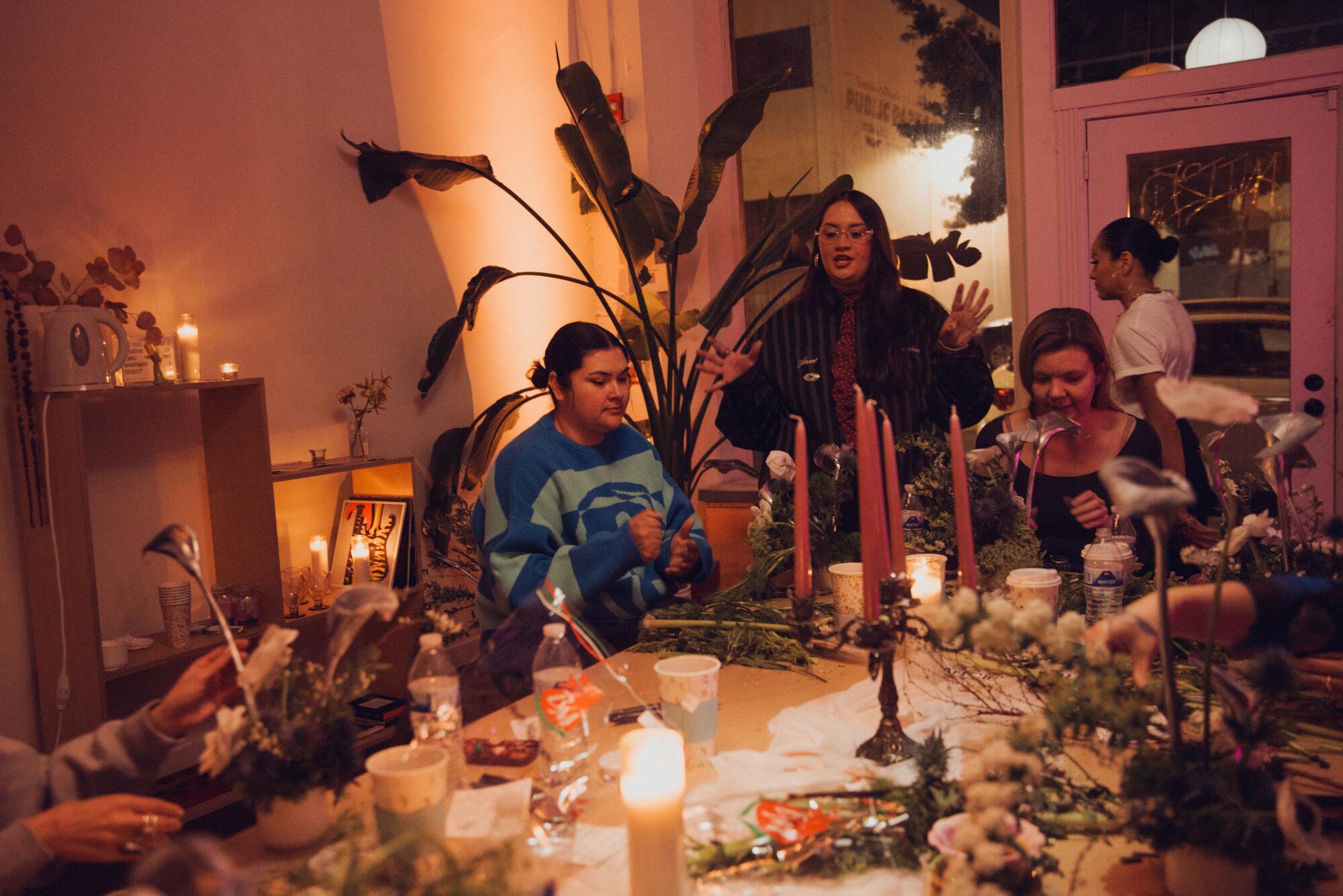 The Flower Hour participants and Vicioso, center, chat as they build their own floral arrangements.