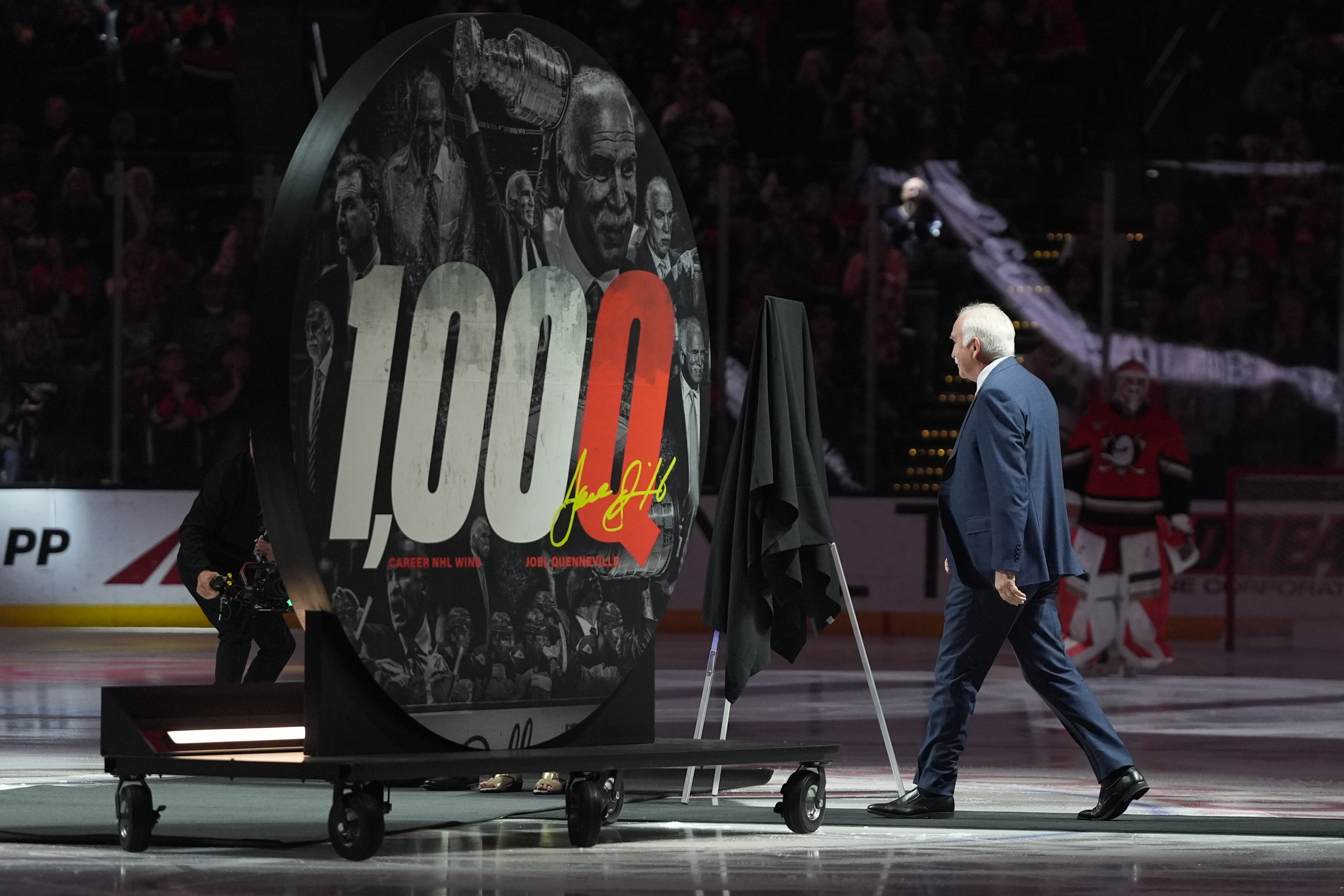 Ducks head coach Joel Quenneville walks onto the ice to...