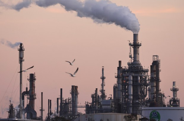 WILMINGTON, CALIFORNIA - NOVEMBER 19: Birds fly near the Phillips 66 Los Angeles Refinery Wilmington Plant after sunset on November 19, 2024 in Wilmington, California. Phillips 66 announced last month that it will close the Los Angeles-area oil refinery, which currently supplies around 8 percent of California's crude oil refining capacity, by the end of next year. (Photo by Mario Tama/Getty Images)