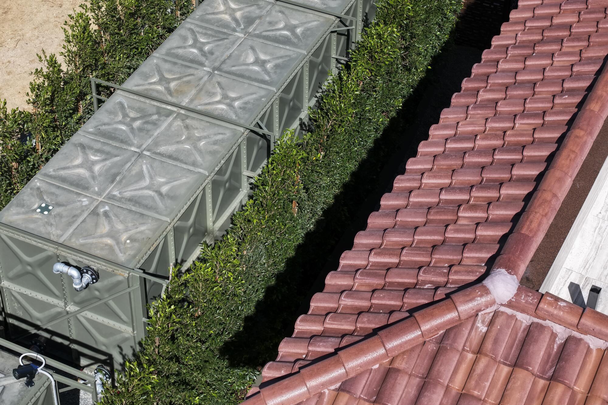 Water tanks surrounded by greenery outside a home.