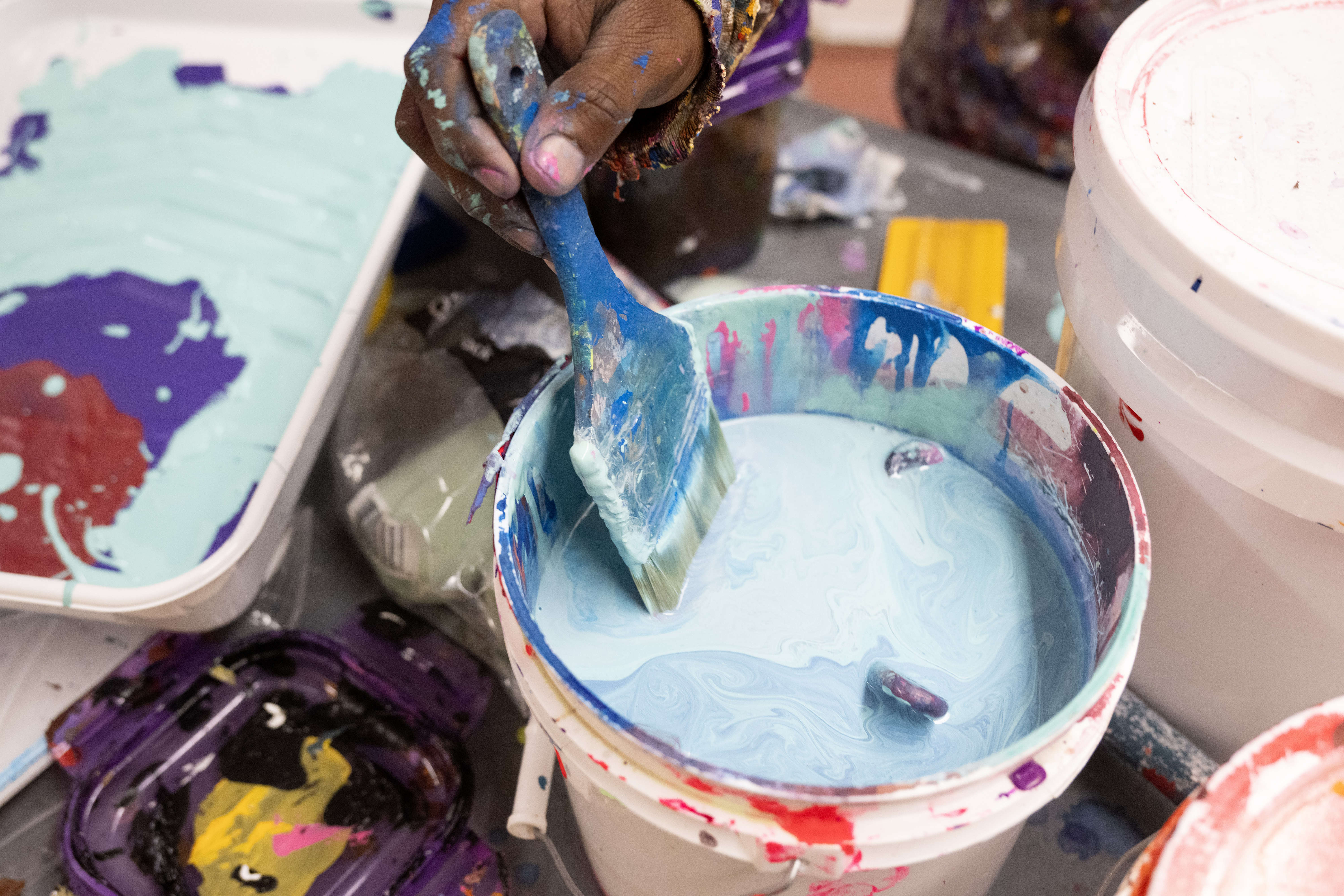 Artist Mike Norice works on a mural at Audubon Middle...