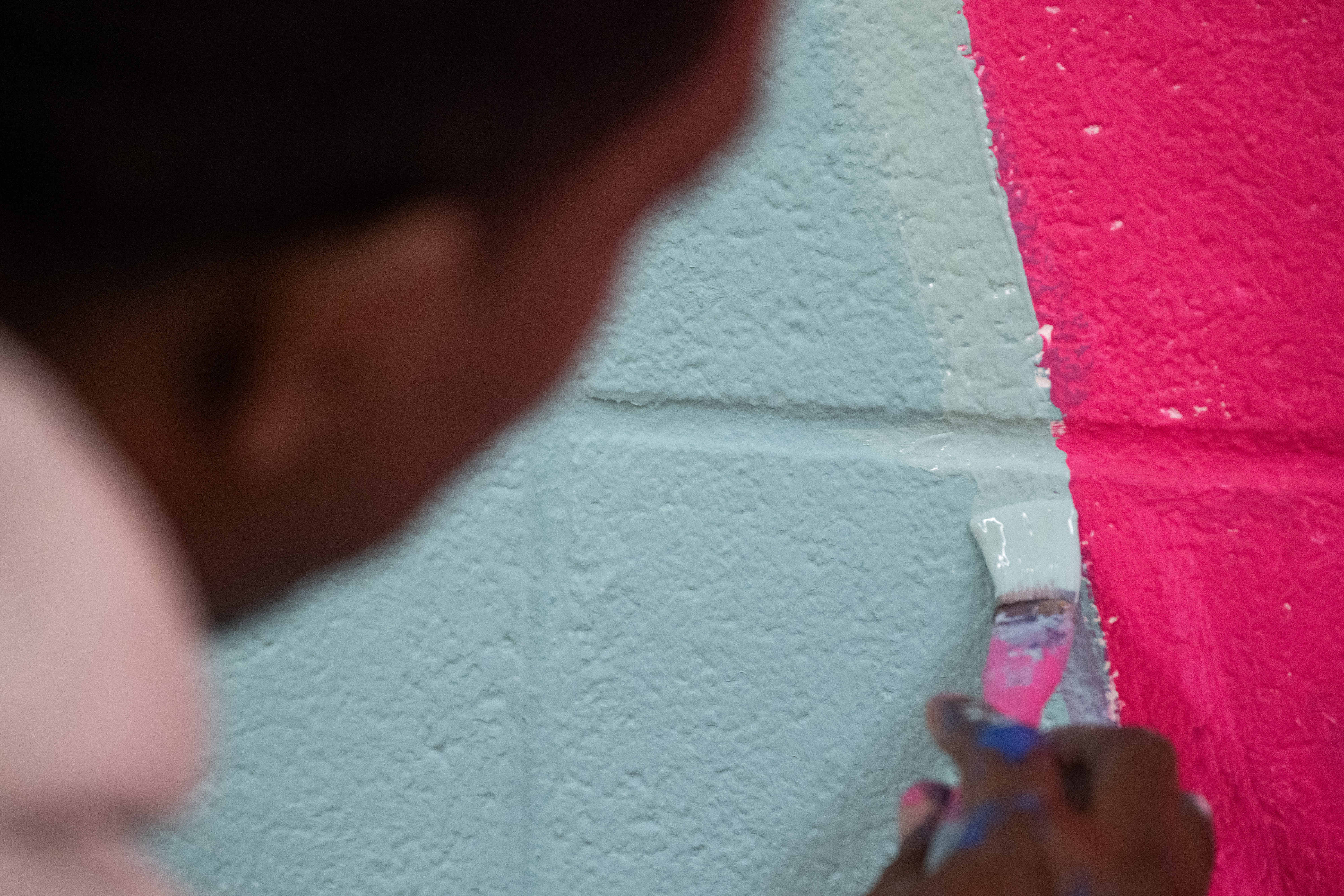 Artist Mike Norice works on a mural at Audubon Middle...