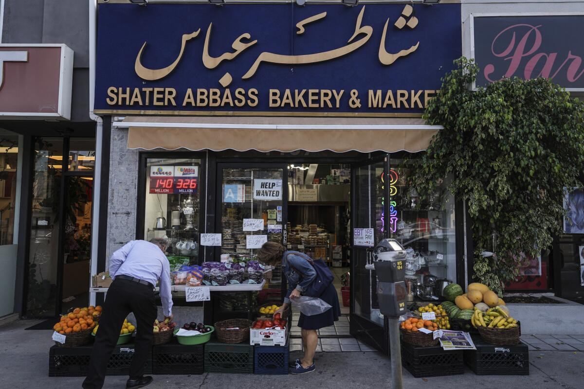Two shoppers select items at a grocery store 