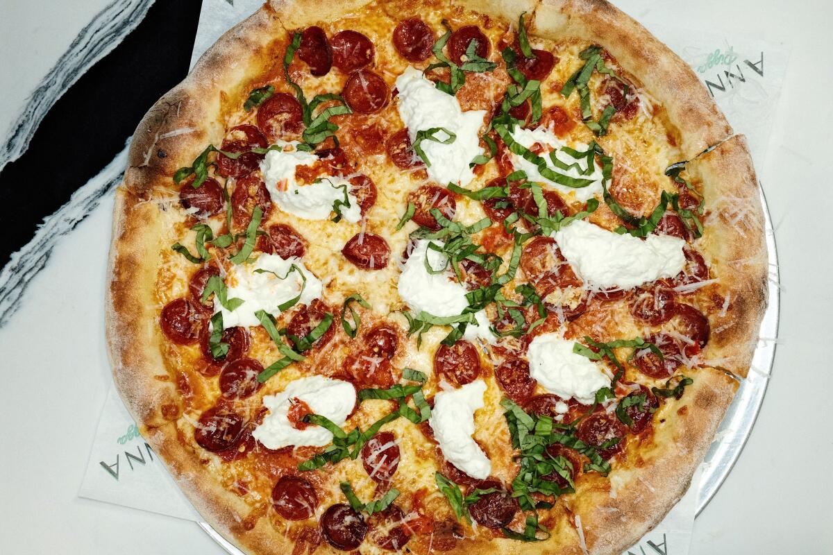 A pizza with pepperoni, mozzarella, garlic, vodka sauce, Calabrian chili, basil and stracciatella.