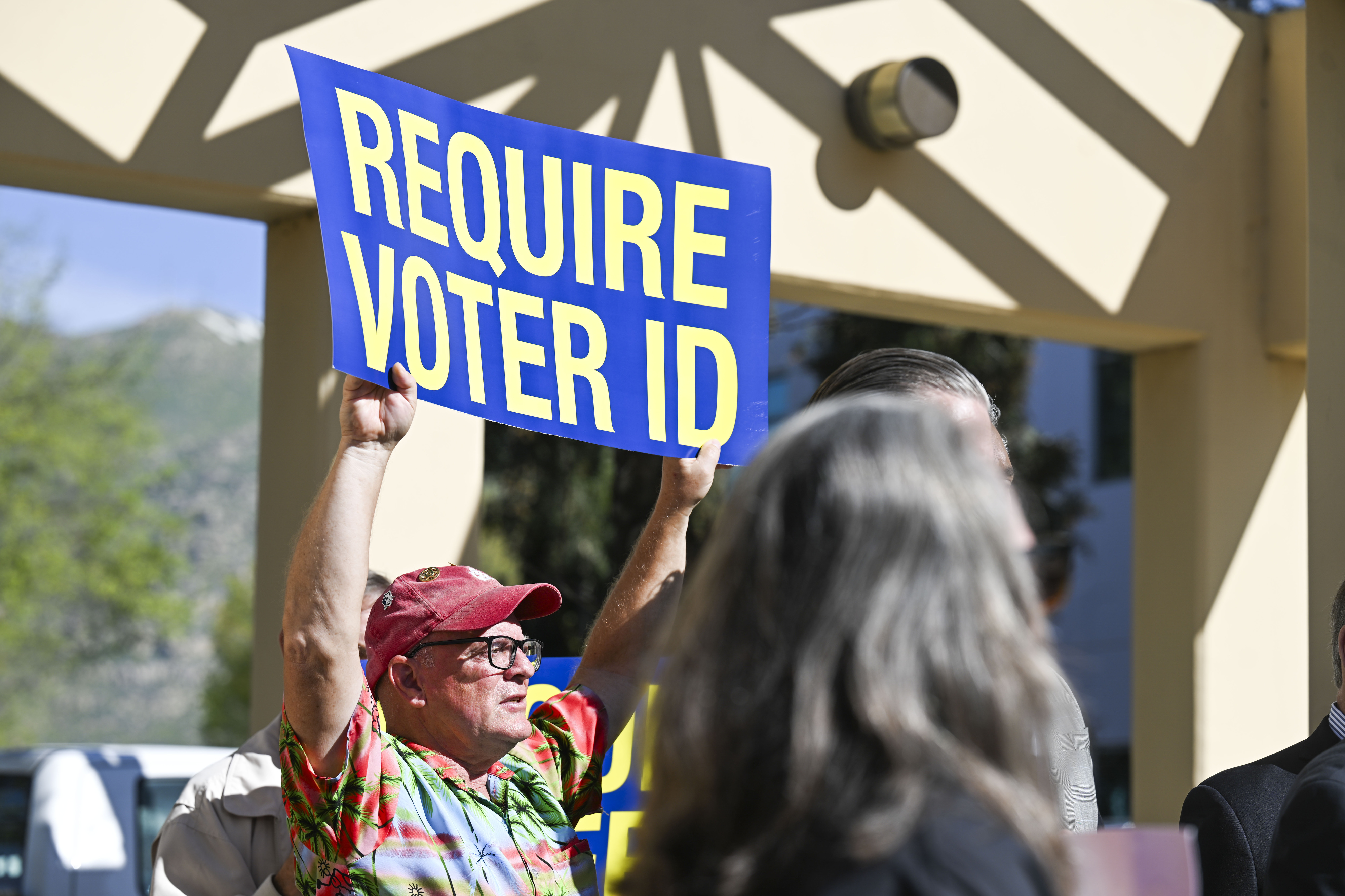 A volunteer supports a voter ID ballot measure Monday, March...