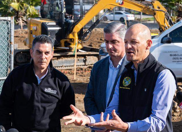 Sacramento Mayor Kevin McCarty, right, speaks as workers build a new safe camping site in the River District on Feb. 27. Department of Community Response Director Brian Pedro, left, and Council Member Phil Pluckebaum, center, joined him at the event.