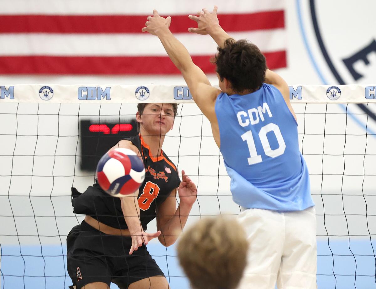 Huntington Beach's Ben Arguello (8) puts a kill past Corona del Mar's Hunter Hanneman (10) on Wednesday.