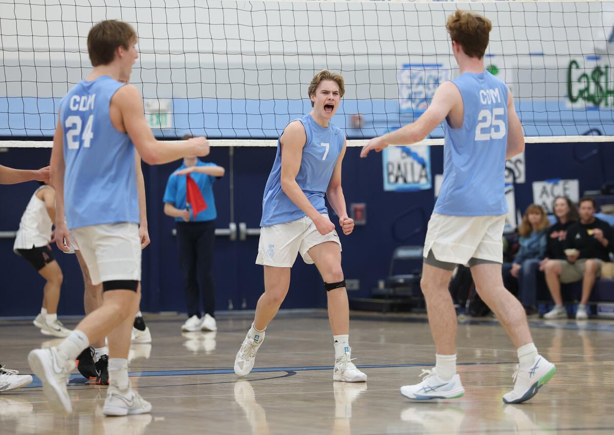 Corona del Mar's Brady Gant (25) celebrates an ace serve with Ben Brown (24) and Drake Foley (7) against Huntington Beach.