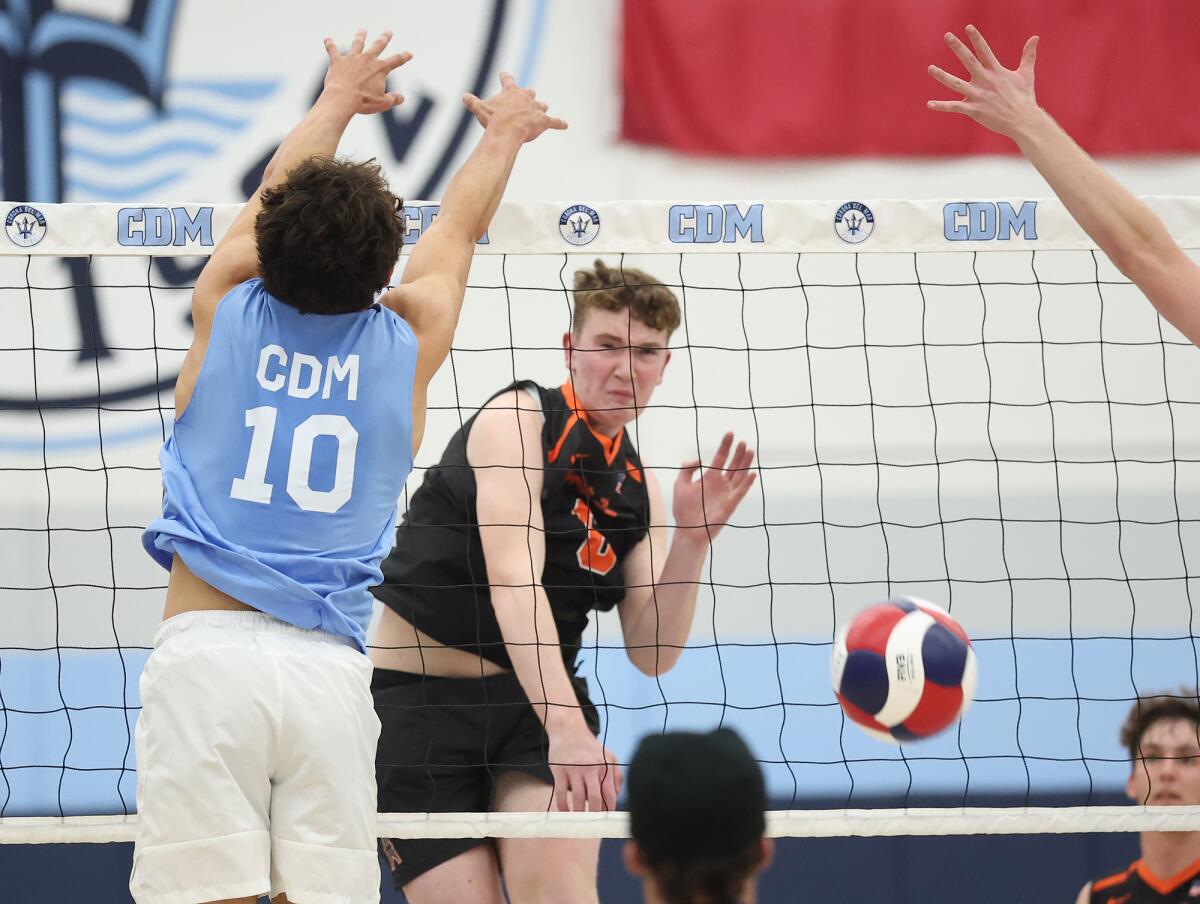 Huntington Beach's Kenno Kosty (6) puts a kill away past Corona del Mar's Hunter Hanneman (10).