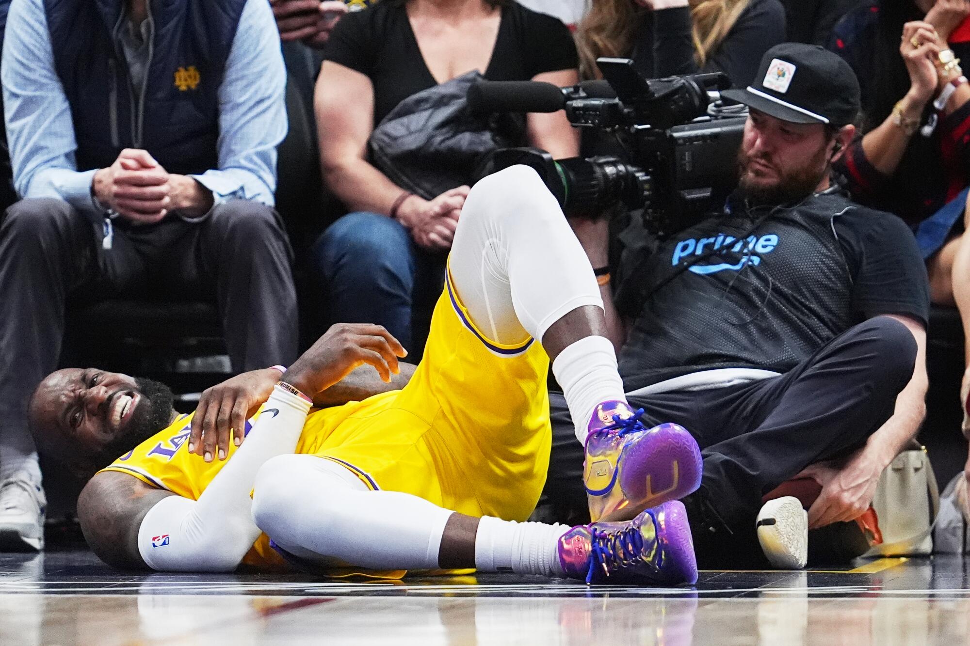 Lakers star LeBron James grimaces after falling to the court during the fourth quarter.