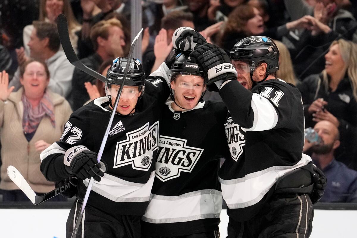 Kings defenseman Mikey Anderson, center, celebrates with forwards Artemi Panarin, left, and Anze Kopitar.