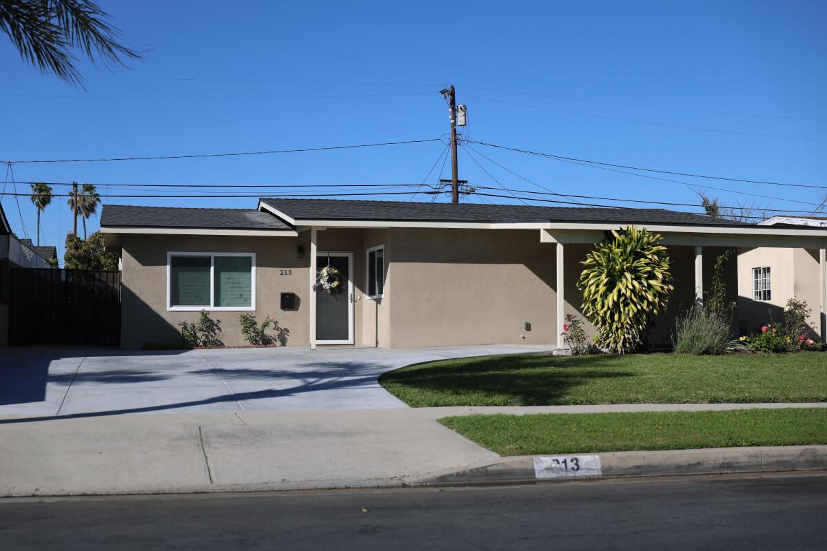 View of a one-story suburban home with a grass lawn 