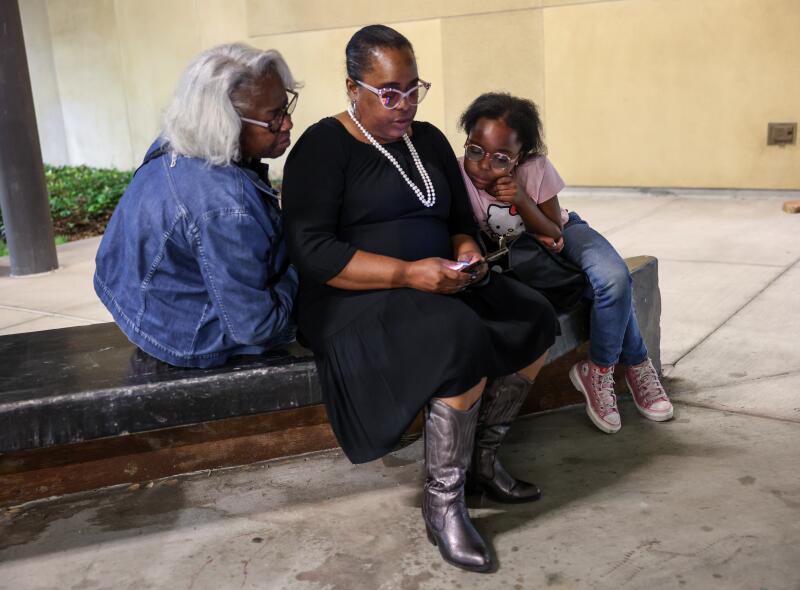 Honey Cooper sits with her mother, Mia, center, and grandmother Pretty Jackson