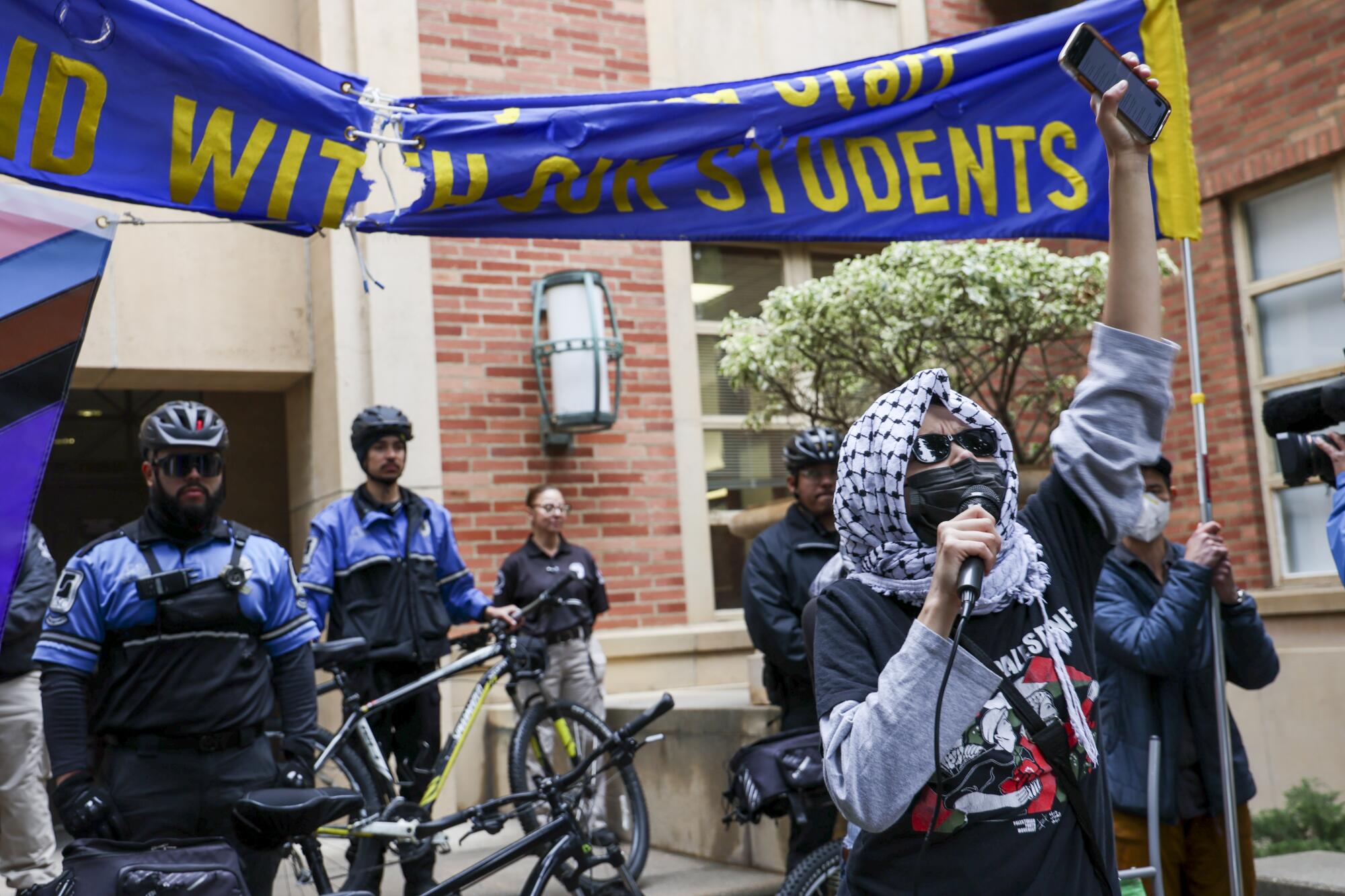Pro-Palestine protesters hold a rally in front of campus police at UCLA