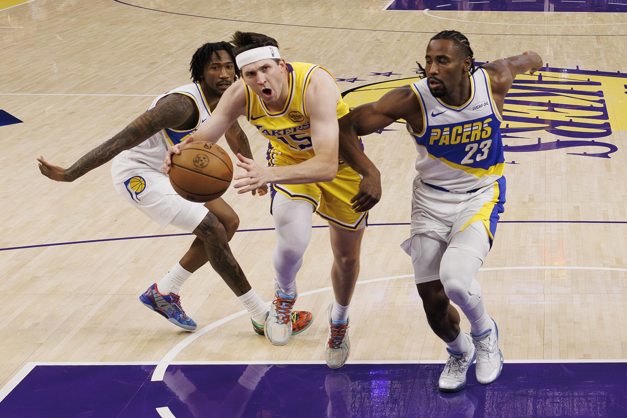 Lakers guard Austin Reaves drives to the basket as he's chased by Pacers guards Quenton Jackson and Aaron Nesmith 