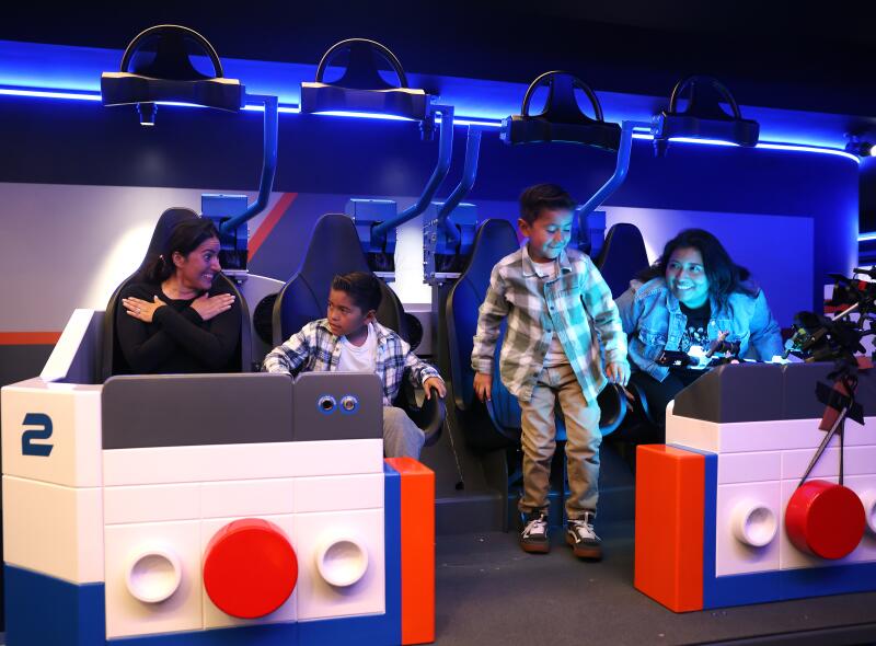 Two adults and two boys are all smiles after riding the new Galacticoaster.