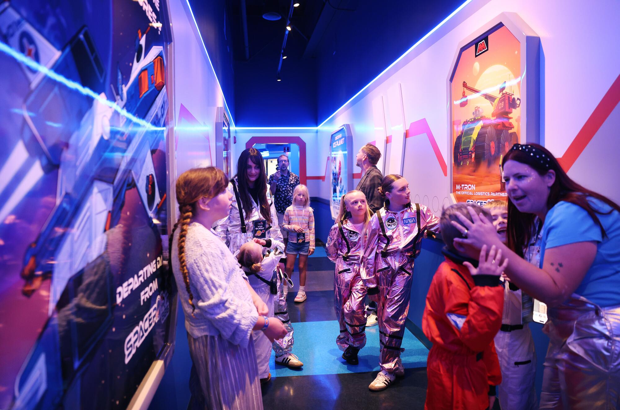 Visitors wait in line to ride the new indoor coaster designed for families.
