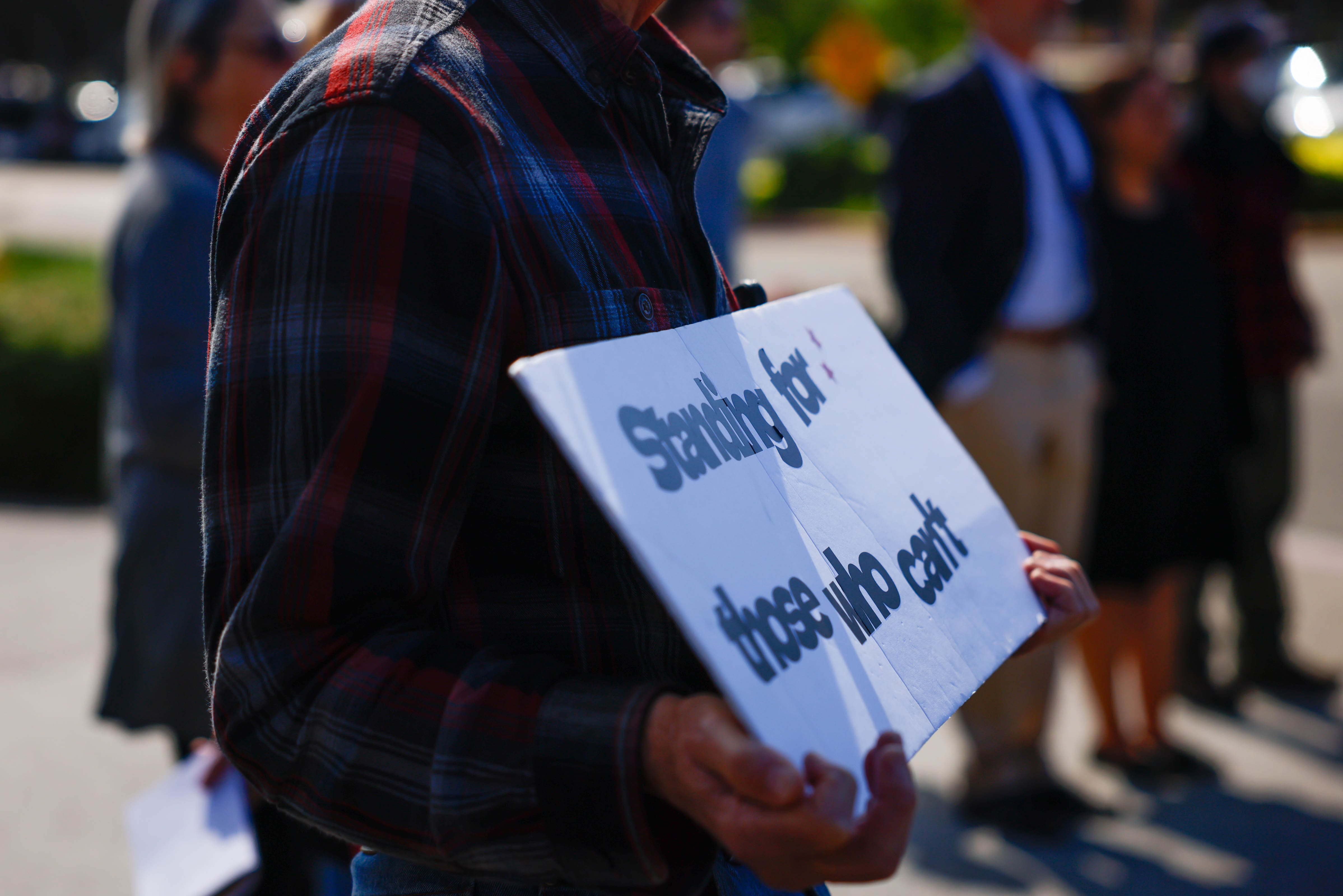A person holds a sign while protesting ICE at Elmwood...