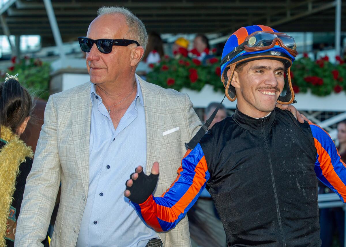 Trainer Richard Baltas, left, and jockey Diego Herrera, right, are all smiles in the Winner's Circle