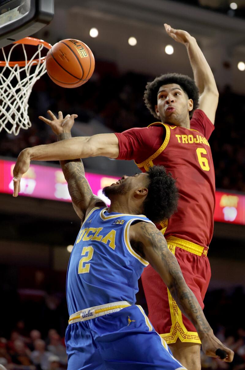 USC forward Jacob Cofie, top, tries to block a shot by UCLA guard Donovan Dent.