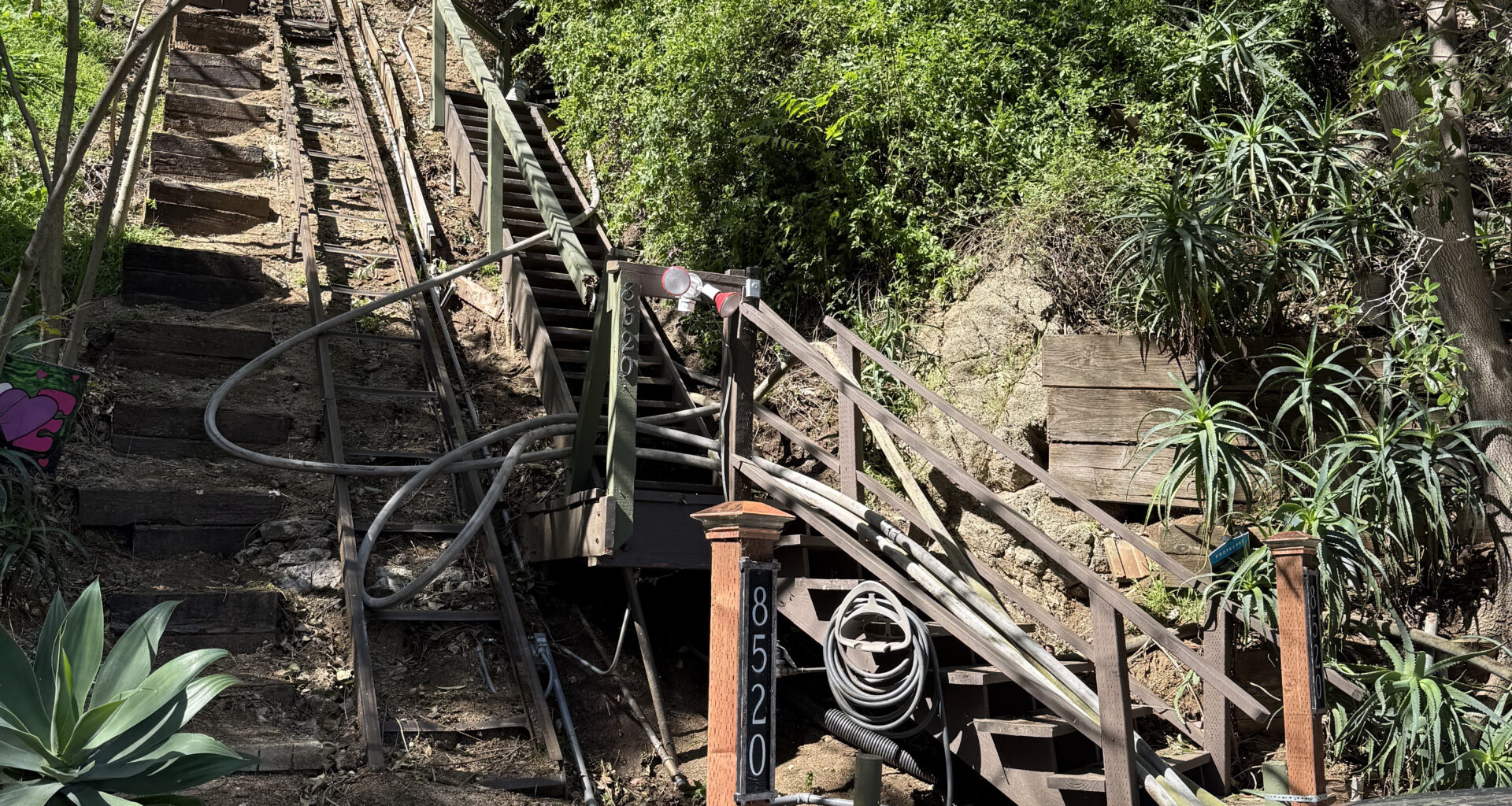 Long, narrow, steep wooden staircase adjacent to the home with the fire lines going up it. Shows how difficult to reach the home