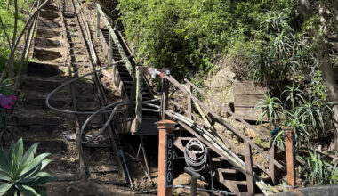 Long, narrow, steep wooden staircase adjacent to the home with the fire lines going up it. Shows how difficult to reach the home