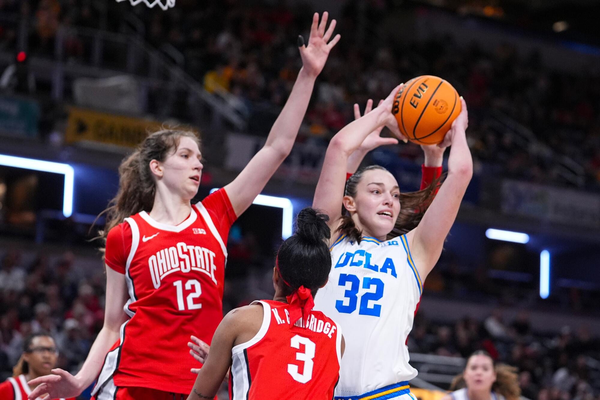 UCLA forward Angela Dugalic passes the ball under pressure from Ohio State center Elsa Lemmila.