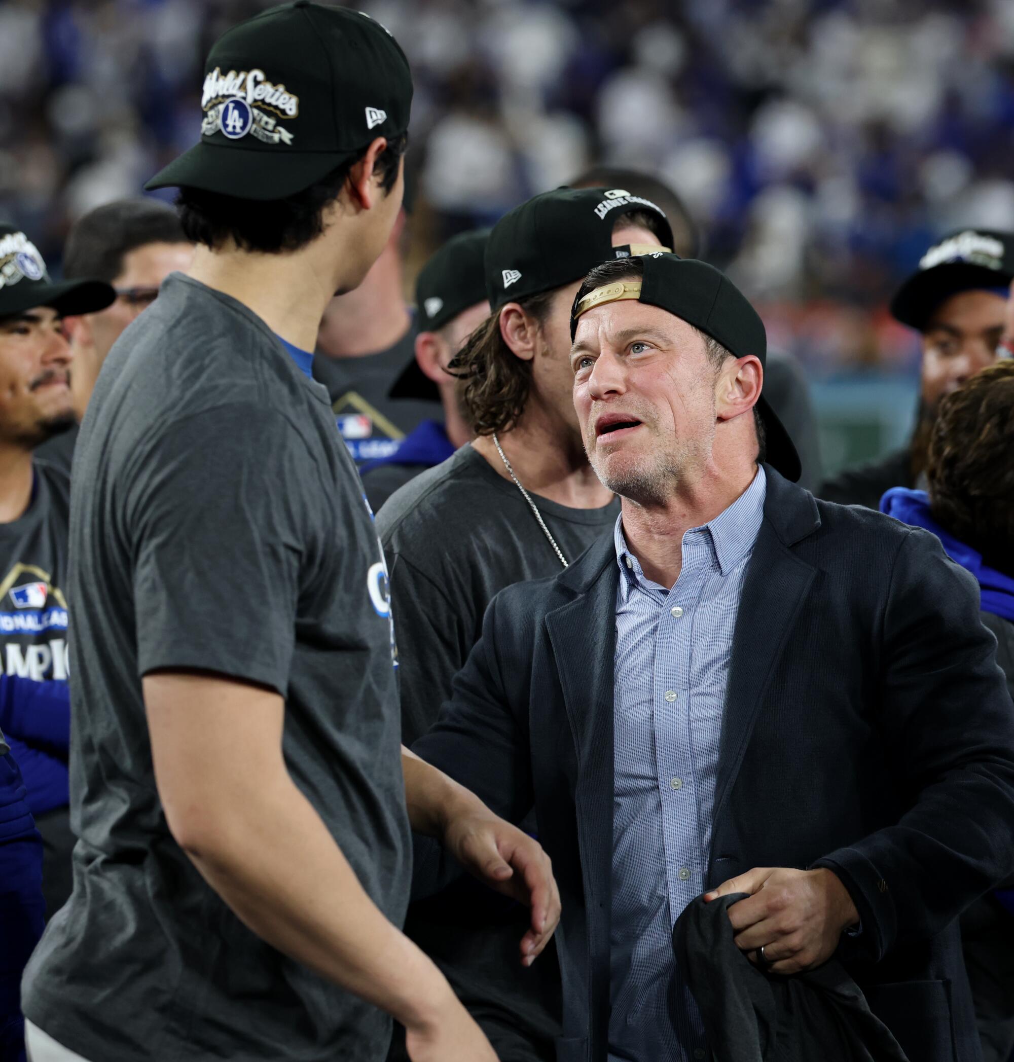 Dodgers two-way player Shohei Ohtani (17) is congratulated by Dodgers' Andrew Friedman after the Dodgers won game four
