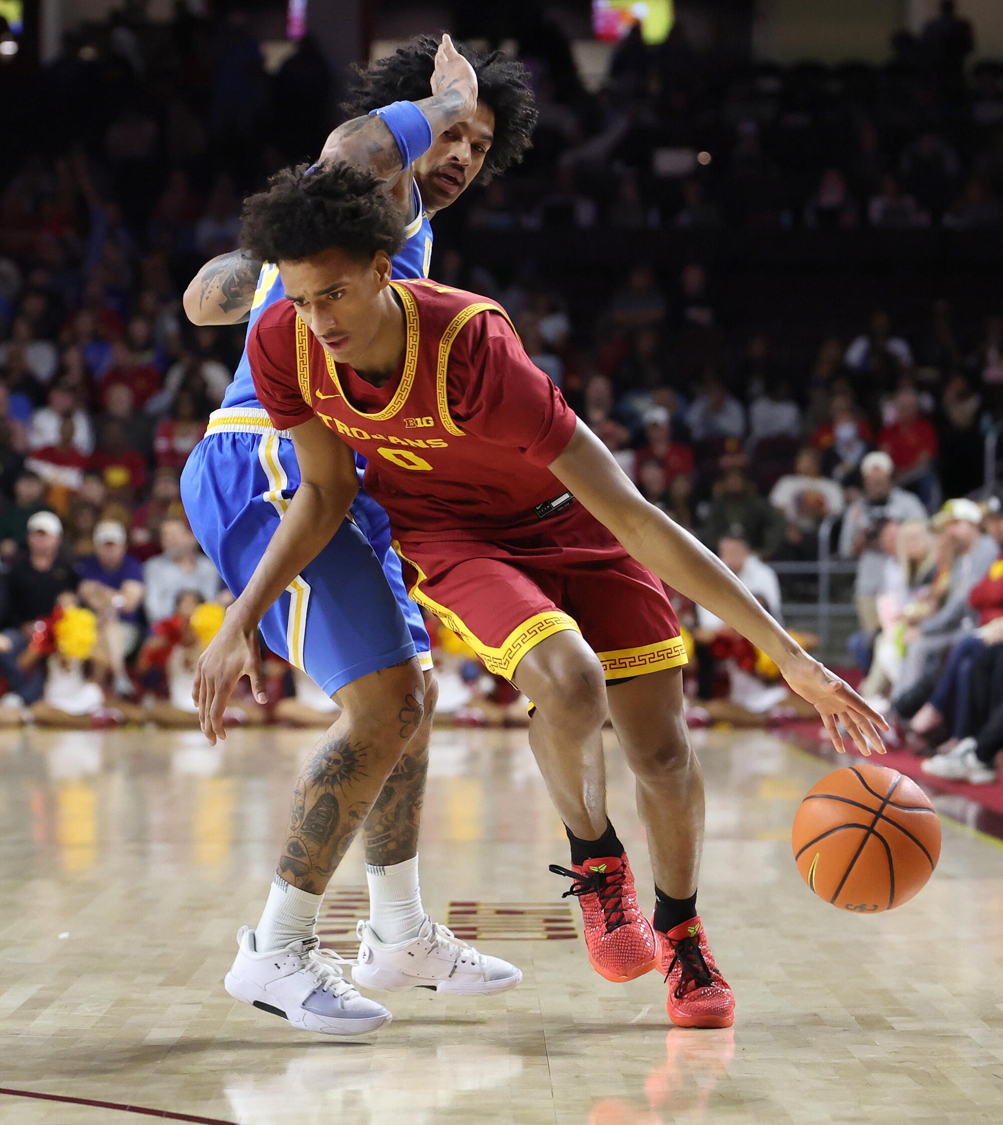 USC guard Alijah Arenas, right, drives past UCLA guard Skyy Clark during the Trojans' loss Saturday night at Galen Center.