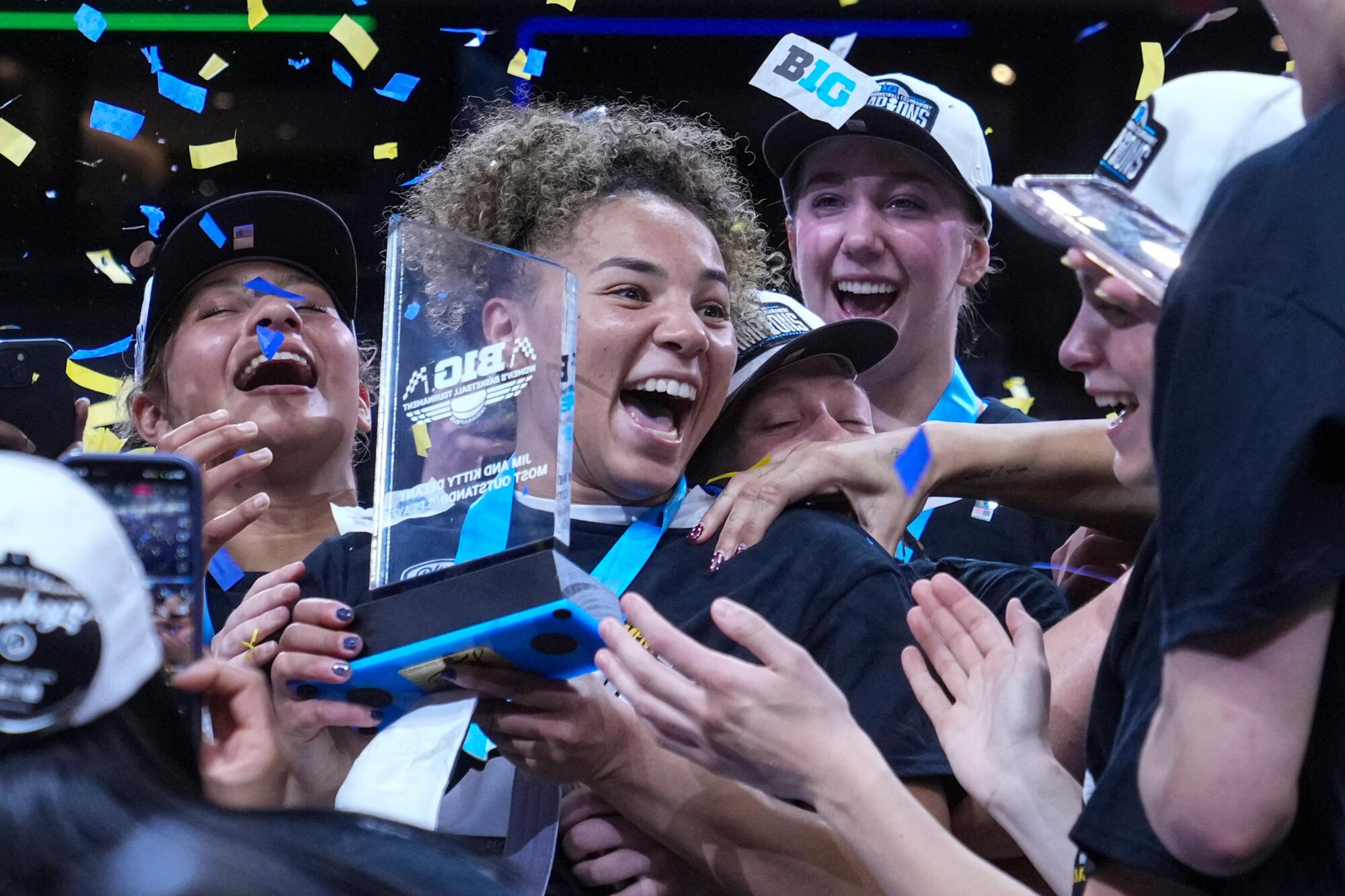 UCLA guard Kiki Rice celebrates with a trophy after receiving the Big Ten tournament most outstanding player honors.