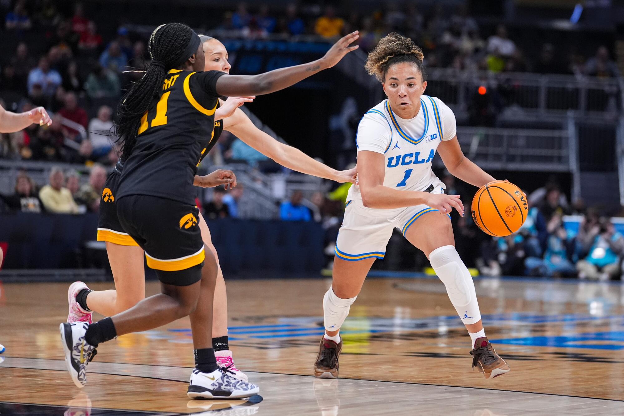 UCLA guard Kiki Rice drives under pressure from Iowa guard Chazadi Wright during the Big Ten tournament finals on Sunday