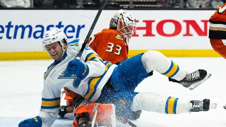 St. Louis Blues right wing Jimmy Snuggerud, front, skates into...