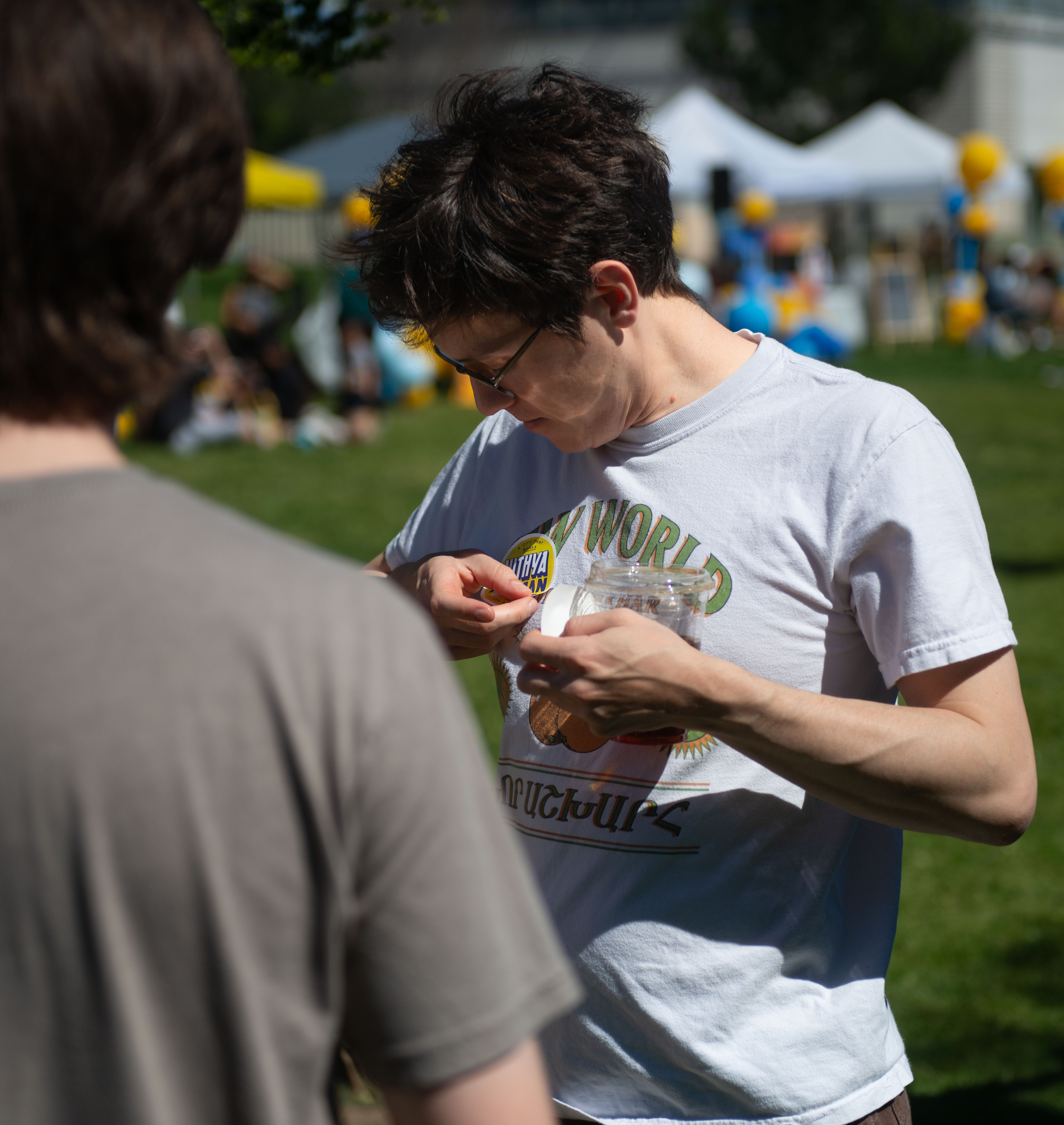 Brett Chalabian places a campaign sticker on his shirt during...