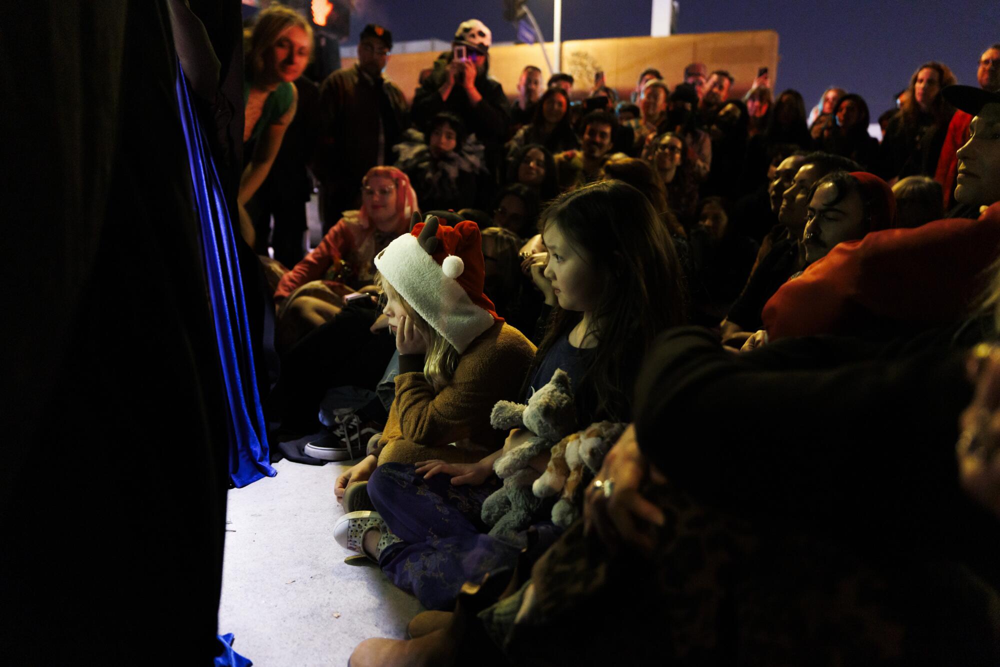 Kids gather in front of a stage.